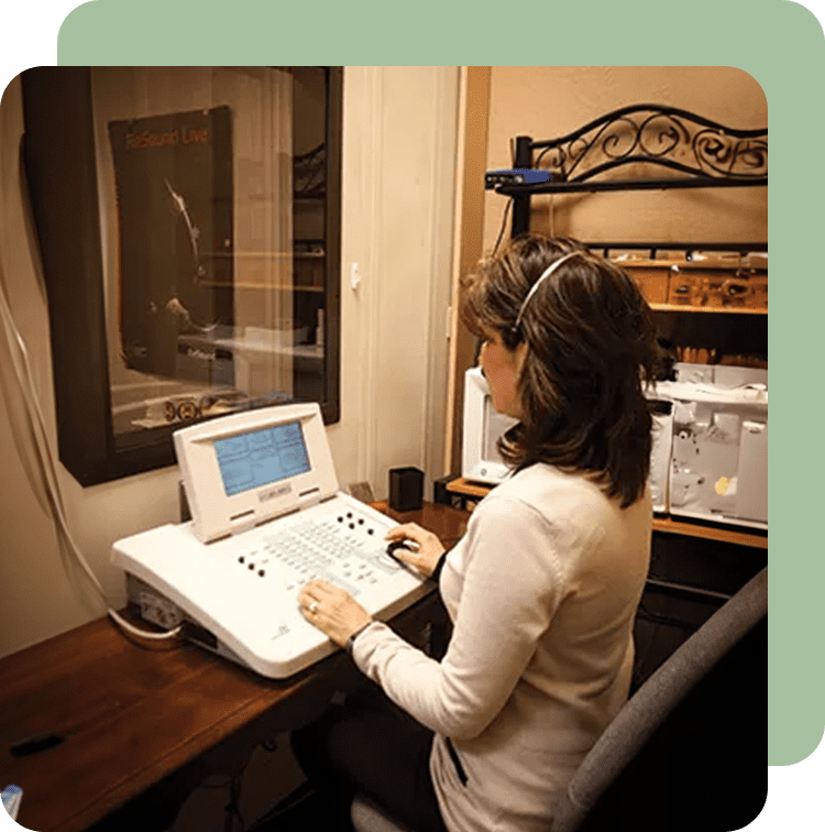 A woman sitting at her desk using a laptop.