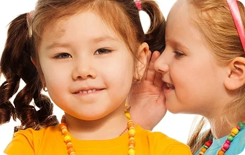 Two little girls are playing with each other.