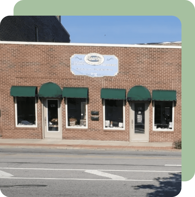 A brick building with green awnings on the side of it.